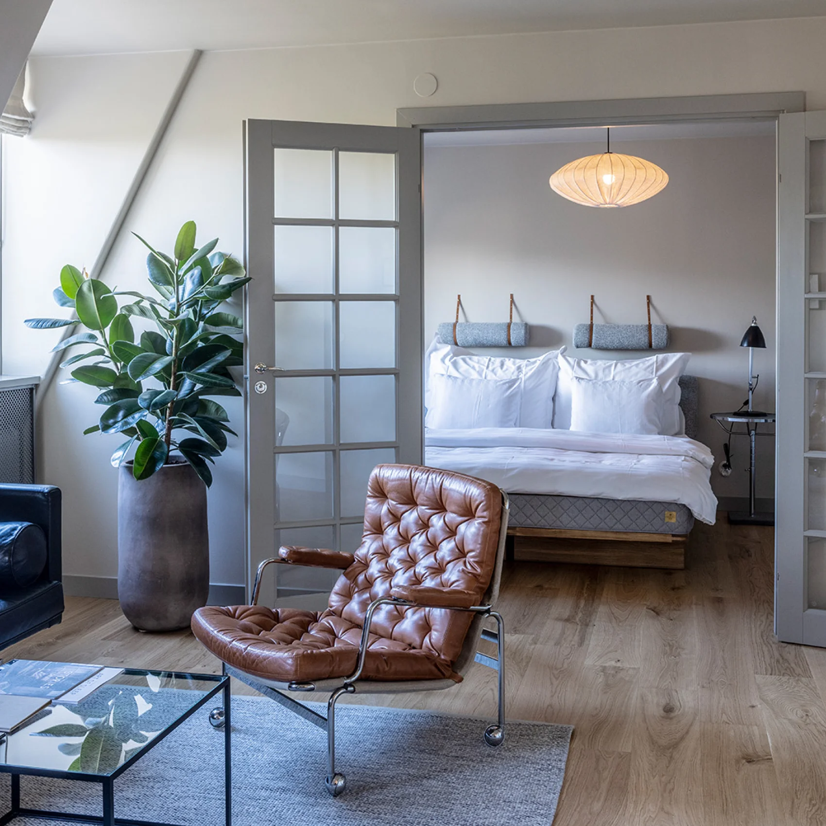Hotelværelse med sofa lænestol og dobbeltseng